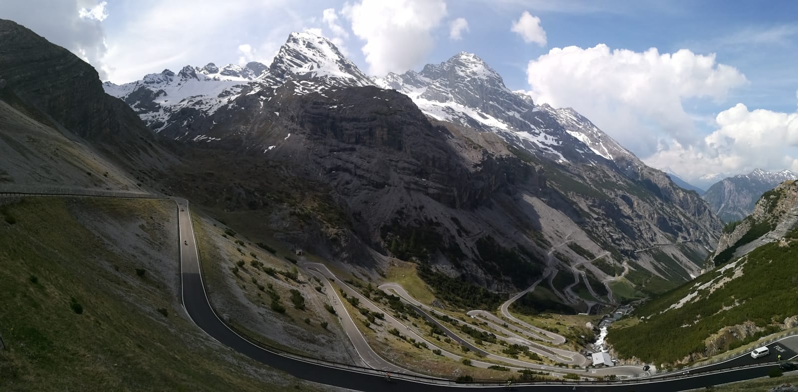A gravel road climbing through high alpine terrain on the Trans Alp route