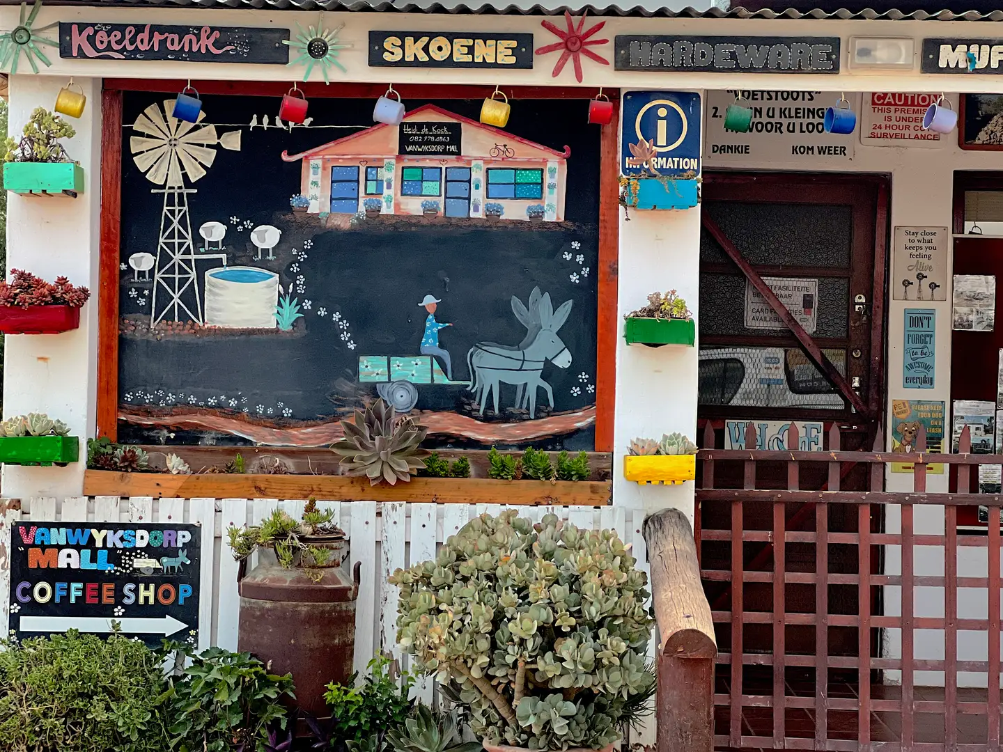 Village coffee shop in Vanwyksdorp with a hand-painted chalkboard mural of a windmill and a donkey cart
